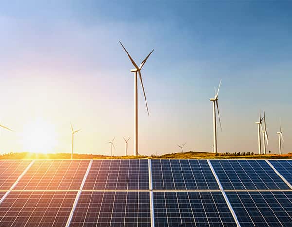 sunset with solar panels and wind towers