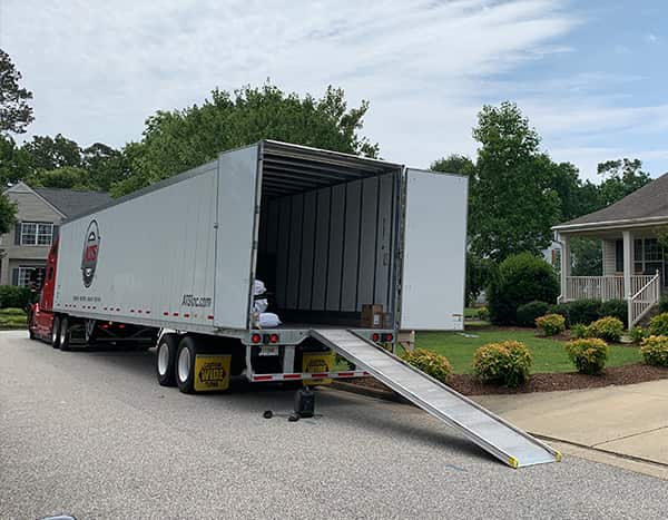 Dry van ramp trailer unloading at residential home