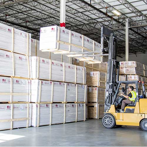 Forklift unstacking cargo at warehouse