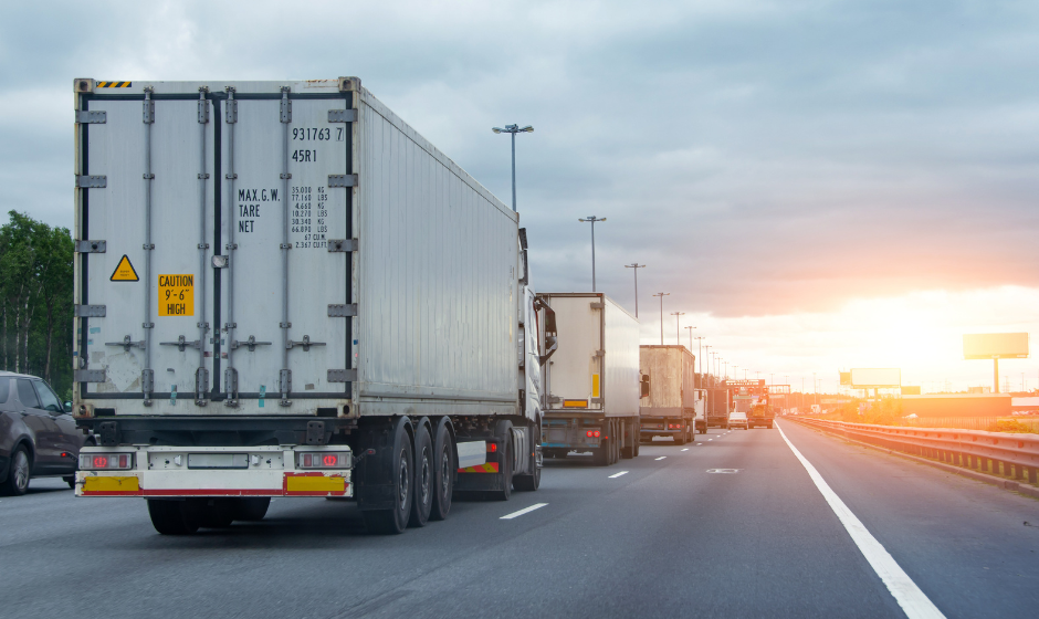 Several dry van trucks traveling in a row