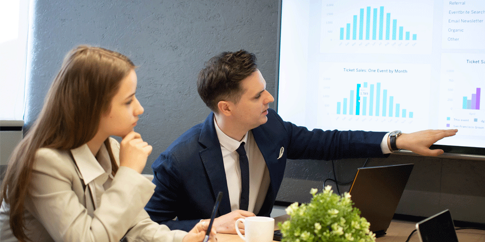 Coworkers reviewing HubSpot data on a large screen together.