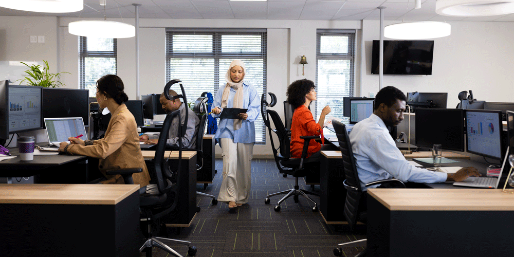 Diverse business people lined up at desks.