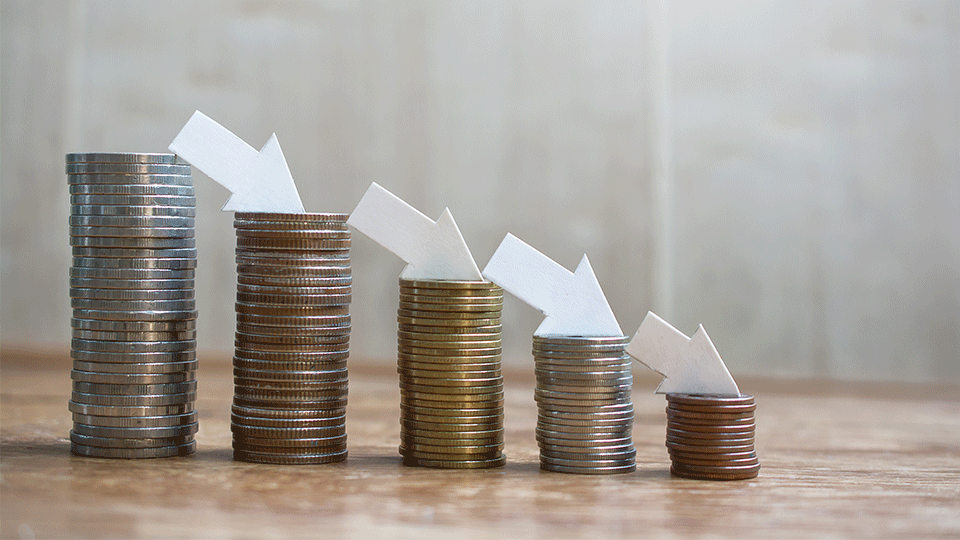 Stacks of currency coins depicting a downward trend
