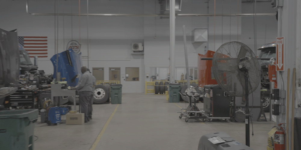 View of a large shop with semi-trucks being worked on.